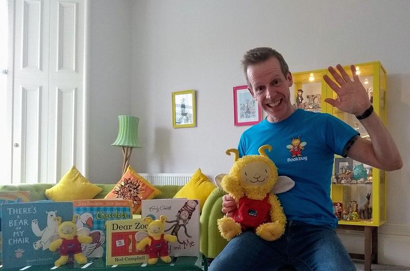 Session Leader holding Bookbug doll, surrounded by books
